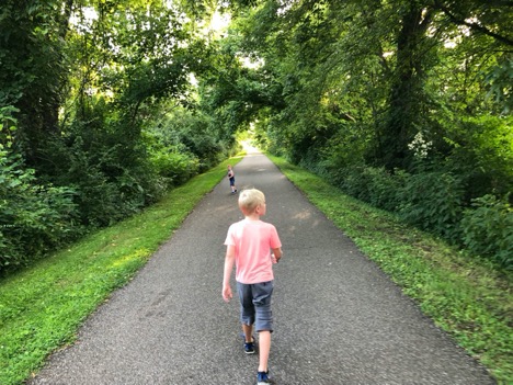 A person riding a bike down a dirt road

Description automatically generated